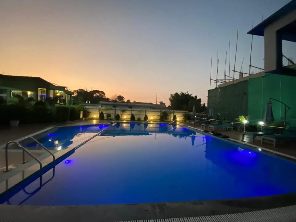 Emmonlang Resort swimming pool at sunset with lights around the deck